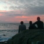 Groupe observant le coucher de soleil sur la mer